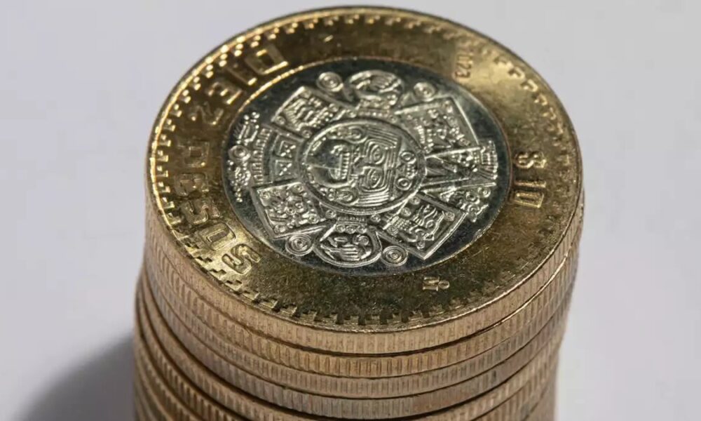 Pila de monedas mexicanas de diez pesos mostrando el diseño central del calendario mexica.
