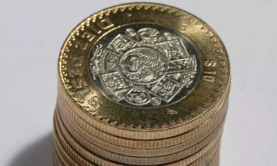 Pila de monedas mexicanas de diez pesos mostrando el diseño central del calendario mexica.