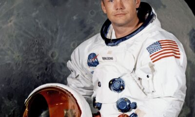Astronauta del Apollo 11 con traje espacial frente a la Luna.