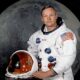 Astronauta del Apollo 11 con traje espacial frente a la Luna.