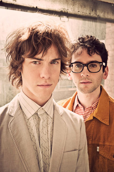 Dos músicos jóvenes en una sesión fotográfica posando; integrantes de una banda internacional.