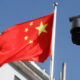 Bandera de China junto a una cámara de videovigilancia simbolizando control y vigilancia social.