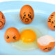 Huevos con expresiones que representan el debate sobre colesterol y salud.