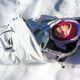 Bebé abrigado descansando en un saco térmico sobre nieve.