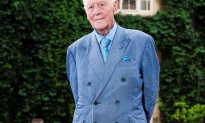 Sir Benjamin Slade, multimillonario británico de 79 años, posando frente a su mansión y un auto de lujo.