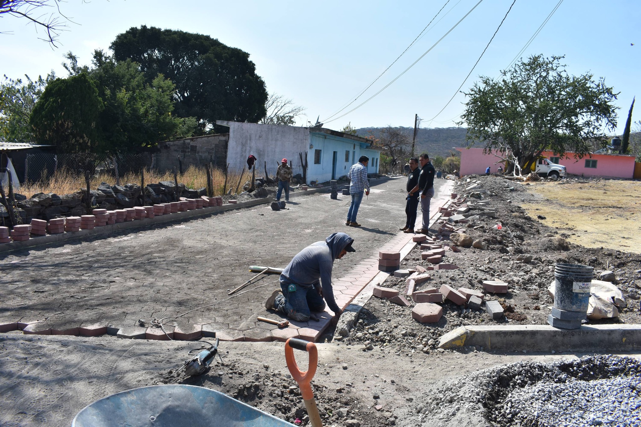 Trabajadores adoquinando una calle en San Pedro Contla durante supervisión de obra.