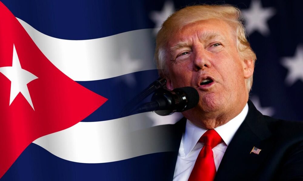 Donald Trump hablando frente a la bandera de Cuba en contexto de tensión geopolítica.