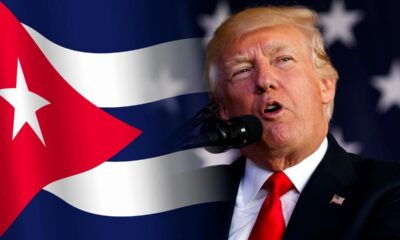 Donald Trump hablando frente a la bandera de Cuba en contexto de tensión geopolítica.