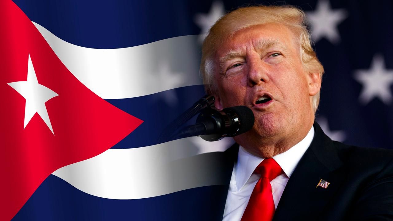 Donald Trump hablando frente a la bandera de Cuba en contexto de tensión geopolítica.