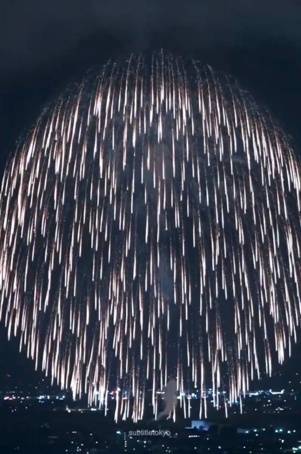Fuego artificial gigante en Japón iluminando la ciudad de noche