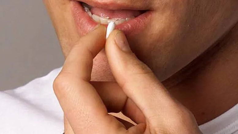 Hombre tomando una píldora anticonceptiva masculina desarrollada por científicos mexicanos.