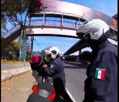 Policías someten a un motociclista en un puente peatonal en México.