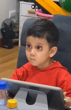 Niño pequeño usando una tableta mientras mira fijamente la pantalla.