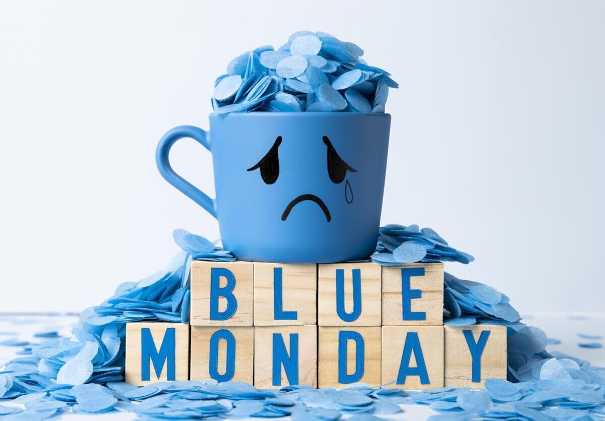 Taza azul con rostro triste y texto Blue Monday representando el concepto del día más triste del año.