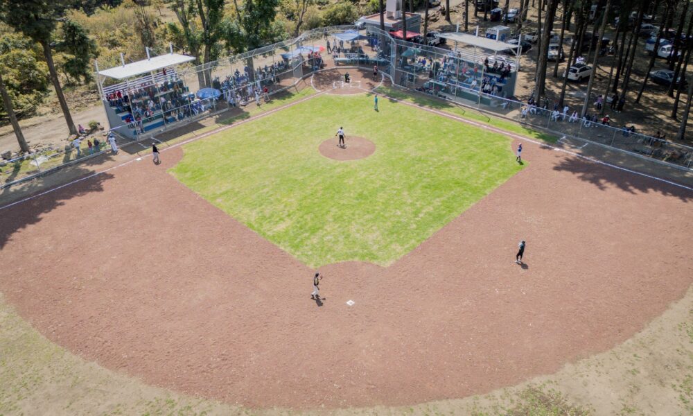 Campo de béisbol con gradas y público durante encuentro deportivo en Santa Catarina Cuilotepec, obra inaugurada por el Ayuntamiento de Tochimilco.