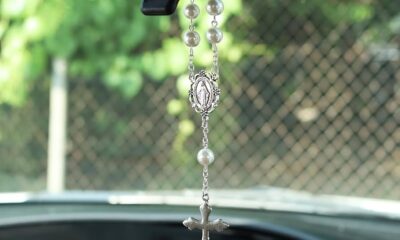 Rosario colgado del espejo retrovisor de un automóvil, objeto considerado distractor visual al conducir