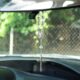 Rosario colgado del espejo retrovisor de un automóvil, objeto considerado distractor visual al conducir