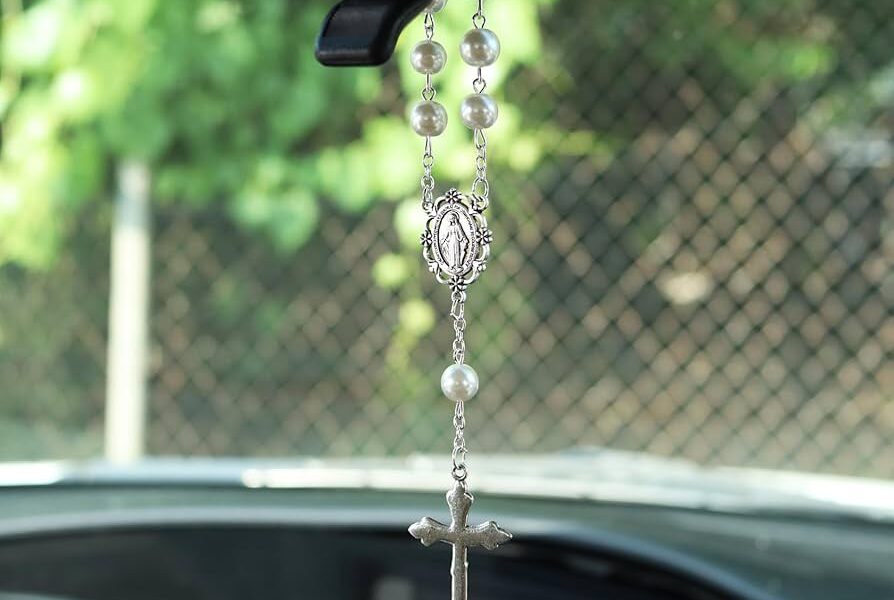 Rosario colgado del espejo retrovisor de un automóvil, objeto considerado distractor visual al conducir