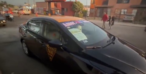 Aviso en taxi colectivo oficial que indica ruta grupal sin paradas sobre el Periférico Ecológico hacia Atlixco y Cholula.