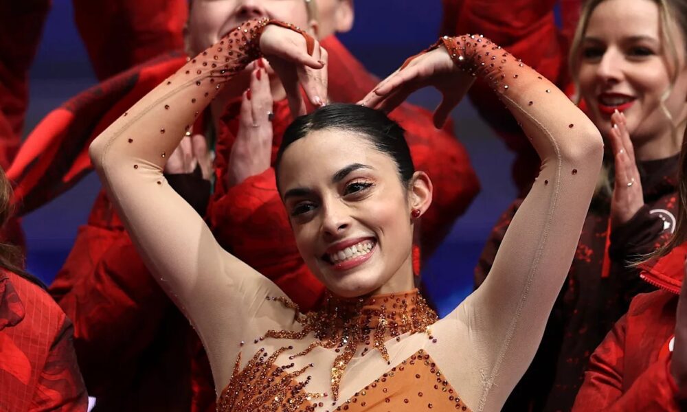 Patinadora artística celebrando durante competencia olímpica, ejemplo de atleta de alto rendimiento y estudiante