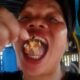 Mujer consumiendo un crustáceo durante grabación de video gastronómico en Filipinas.