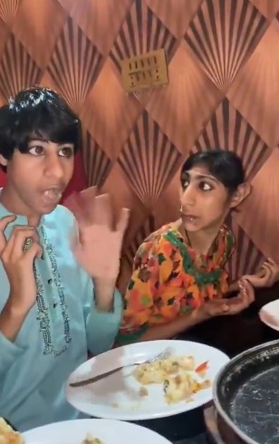Personas conversando durante una comida familiar en Pakistán, reflejo de la vida cotidiana y estructuras sociales tradicionales.