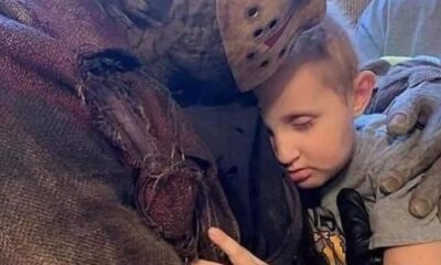 Cosplayer de Jason Voorhees acompañando de forma afectuosa a un niño pequeño, en un momento de consuelo emocional.