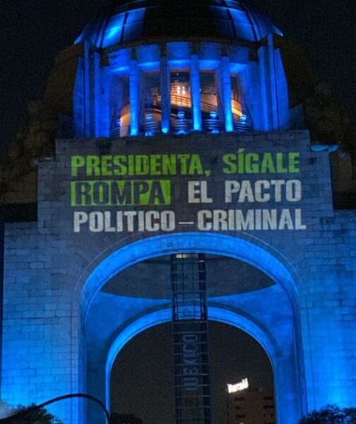 Monumento a la Revolución iluminado con una proyección nocturna que muestra un mensaje político del colectivo Mexicanos al Grito de Paz.