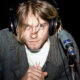 Músico durante una entrevista radial en los años noventa, usando audífonos y micrófono en estudio.x