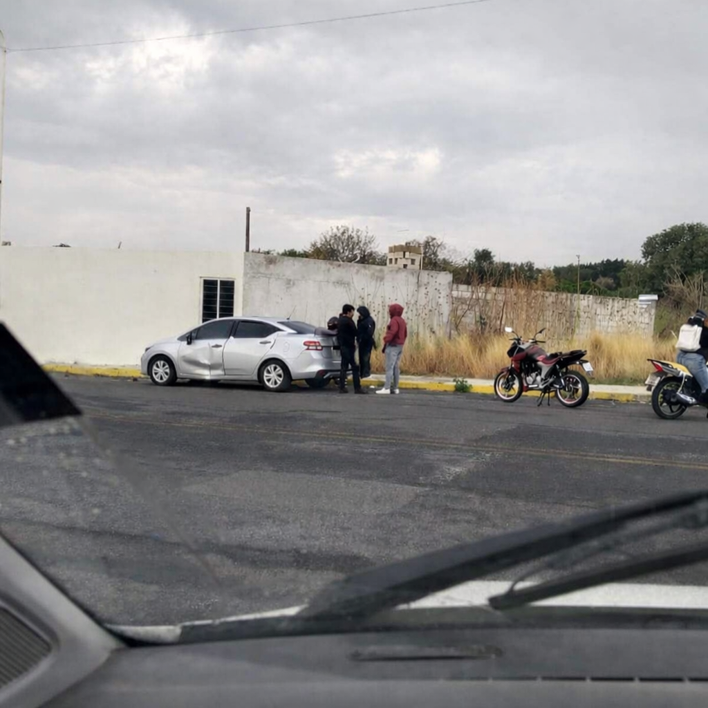Accidente vial en Atlixco frente a escuela con vehículo gris y presencia de autoridades