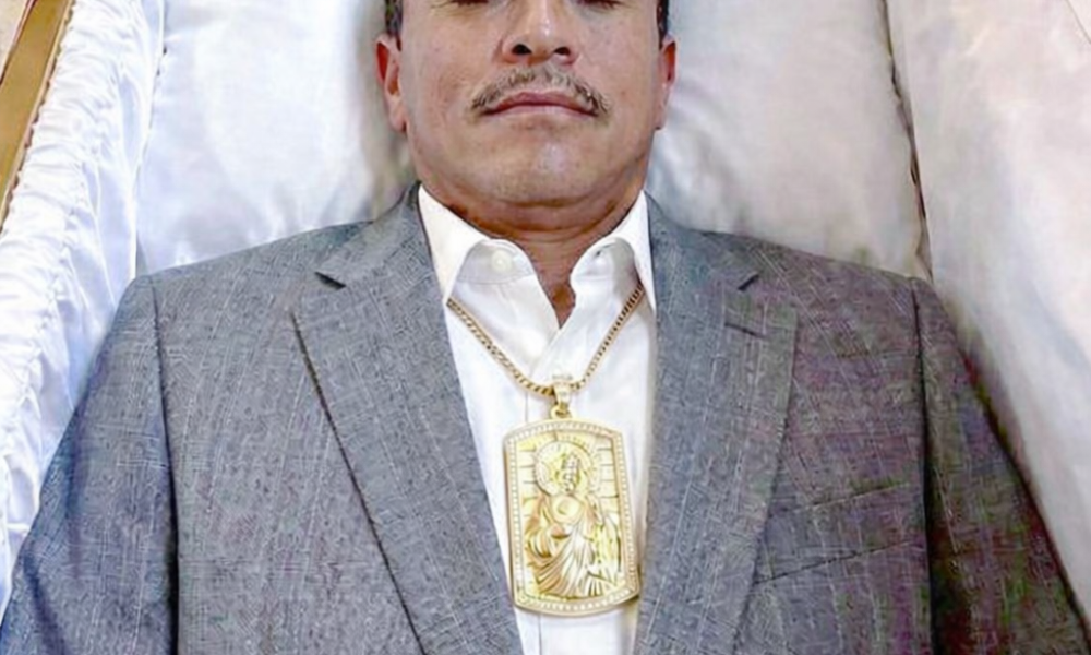 Fotografía viral de hombre dentro de un ataúd con traje y medallón dorado asociada a rumores sobre líder del narcotráfico en México.