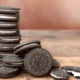 Galletas Oreo de chocolate con relleno de crema apiladas sobre una mesa, símbolo del famoso sándwich dulce creado en 1912.