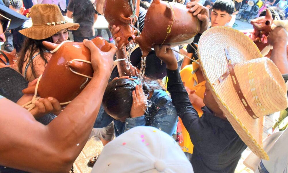 Personas participando en tradición de toritos de agua de gloria en Huaquechula Puebla durante celebración comunitaria con uso de agua
