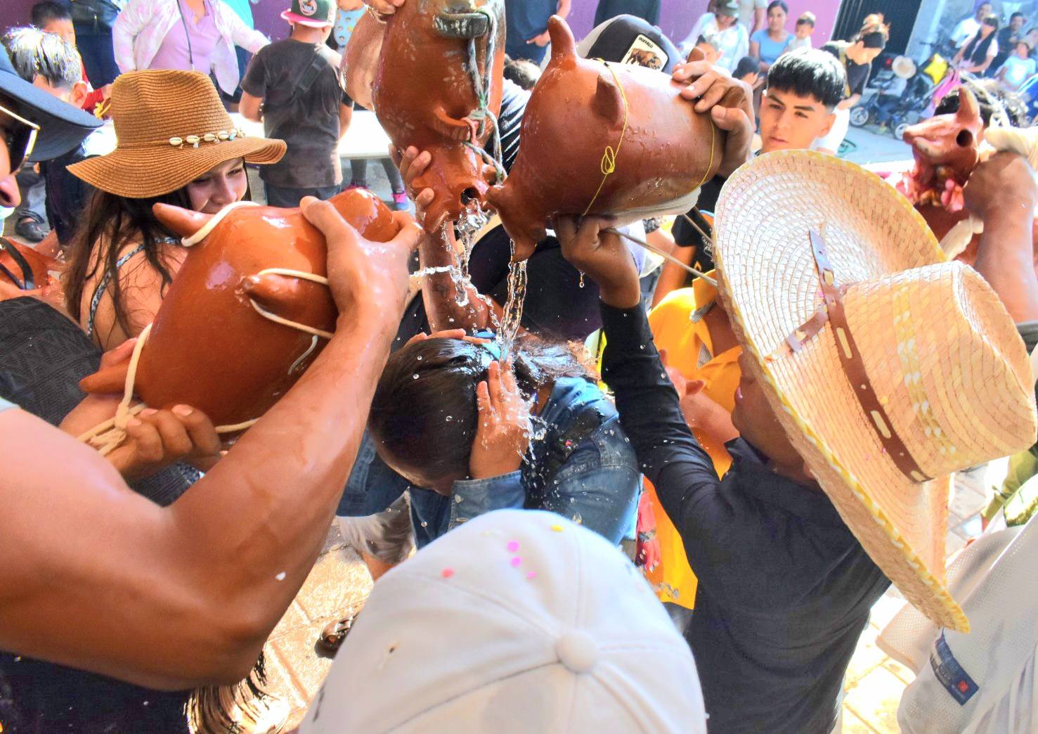 Personas participando en tradición de toritos de agua de gloria en Huaquechula Puebla durante celebración comunitaria con uso de agua