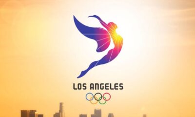 Logotipo de Juegos Olímpicos Los Ángeles con figura estilizada y anillos olímpicos.