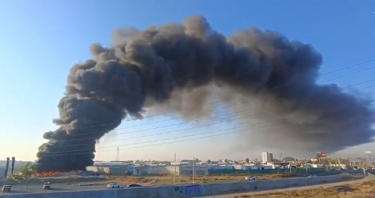 Gran columna de humo negro por incendio en Puebla visible desde periférico ecológico.