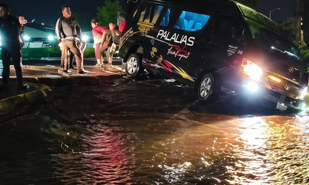 Vehículo atrapado en calle inundada por lluvias en zona en reparación sin señalización en Atlixco