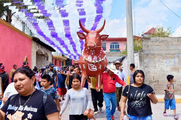 Personas participando en desfile con torito de agua de gloria en San Juan Huiluco Huaquechula durante Semana Santa