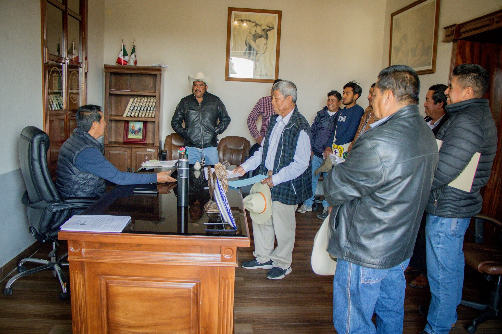 Ciudadanos siendo atendidos por autoridades municipales en oficina durante jornada de atención ciudadana en Tochimilco