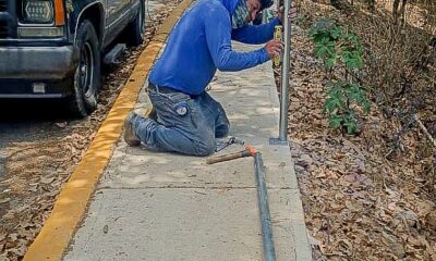 Trabajador instalando malla ciclónica en vialidad de Tochimilco para proteger a estudiantes cerca de barranca