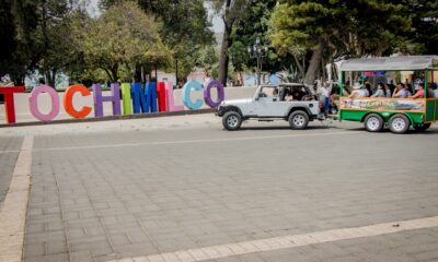 Turismo en Tochimilco con recorrido guiado frente al letrero del municipio en Puebla