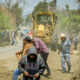 Faena comunitaria en Tochimilco con maquinaria y ciudadanos limpiando cunetas en la entrada principal del municipio