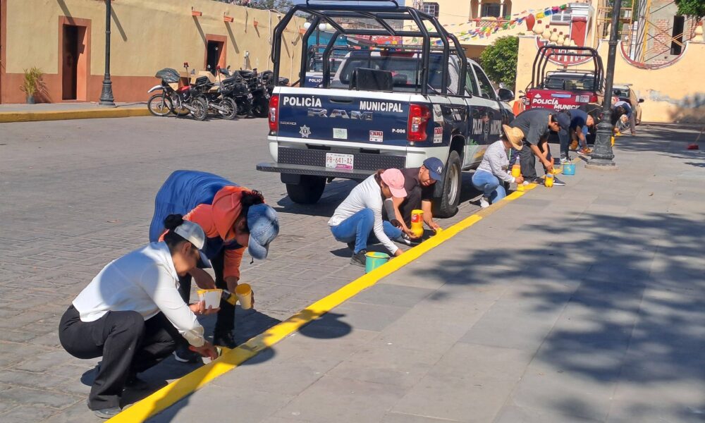 Trabajadores del Ayuntamiento de Huaquechula pintan guarniciones durante jornada de faena en el zócalo municipal