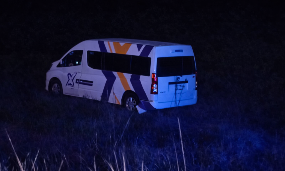 Combi de transporte público fuera de la carretera en zona de matorrales durante accidente nocturno en Puebla