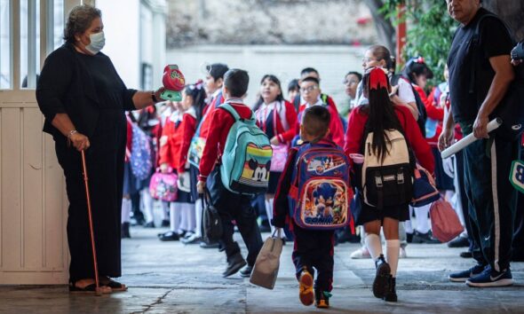 Niños con mochilas regresan a clases en escuela primaria en Puebla