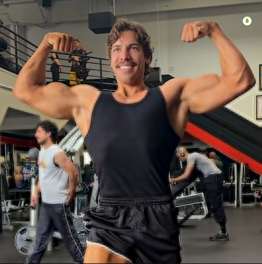 fisicoculturista posando en gimnasio mostrando músculos tras ganar competencia de culturismo