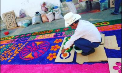 Persona elaborando alfombra de aserrín colorida en Atlixco durante Semana Santa