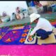 Persona elaborando alfombra de aserrín colorida en Atlixco durante Semana Santa