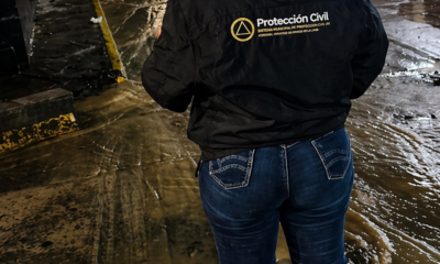 Elemento de Protección Civil supervisando calle inundada en Atlixco durante la noche tras lluvias