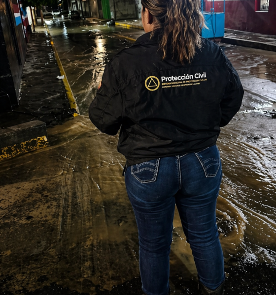 Elemento de Protección Civil supervisando calle inundada en Atlixco durante la noche tras lluvias